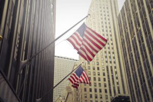 shot-two-american-us-flags-high-rise-building-1-scaled