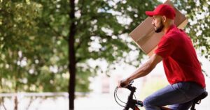 vista-lateral-entregador-carregando-parcela-de-bicicleta