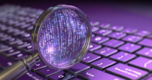 magnifying-glass-revealing-binary-code-purple-keyboard
