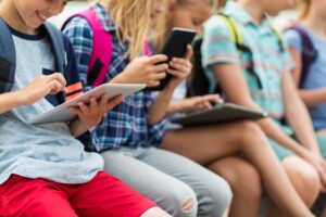 primary-education-childhood-technology-people-concept-close-up-elementary-school-students-with-backpacks-tablet-pc-computers-scaled